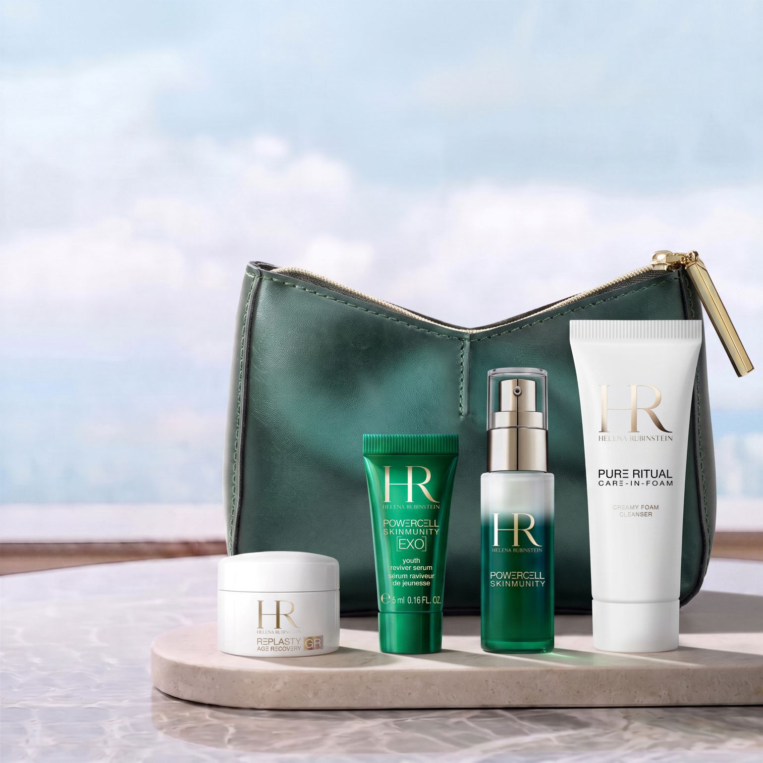 Eine grune Kosmetiktasche von Helena Rubinstein vor einer hellen Landschaft, umgeben von vier Miniatur-Hautpflegeprodukten: einer Re-Plasty Creme, einem Powercell [EXO] Mini-Serum, einem Powercell Skinmunity Serum und einem Pure Ritual Cleanser.​