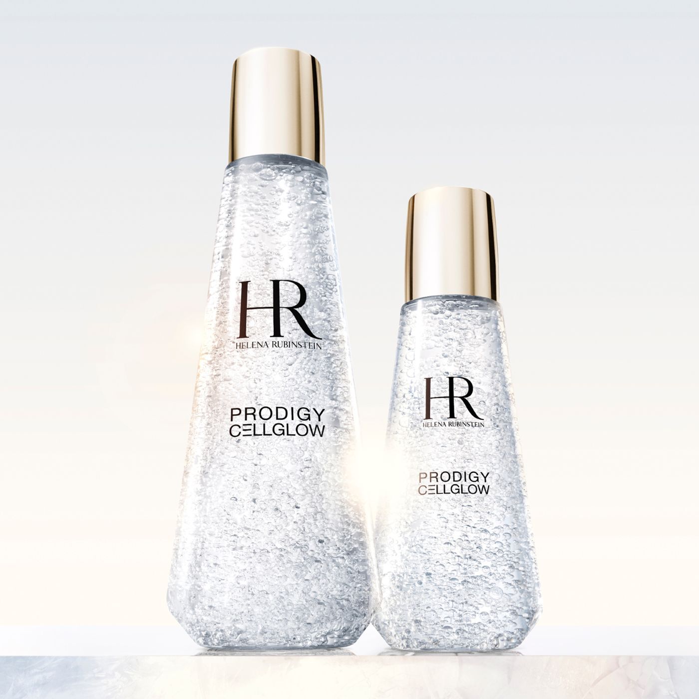 Helena Rubinstein Prodigy Cellglow: die Essenz regenerierter Haut. Zwei kristallklare Flaschen, ihre feinen Blaschen das Licht spiegelnd, versprechen eine Wiedergeburt von Strahlkraft und Vitalitat. Die Kunst des Lichts auf der Haut.