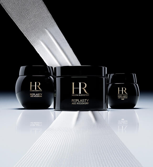 Drei schwarze Helena Rubinstein Re-Plasty Age Recovery Cremetiegel, ein großer in der Mitte und zwei kleinere an den Seiten, mit weißen Bandern, die an Verbande erinnern, auf dunklem Hintergrund.