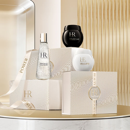 HR Luxus-Hautpflege und Geschenkboxen auf einem geriffelten goldenen Studiohintergrund.​