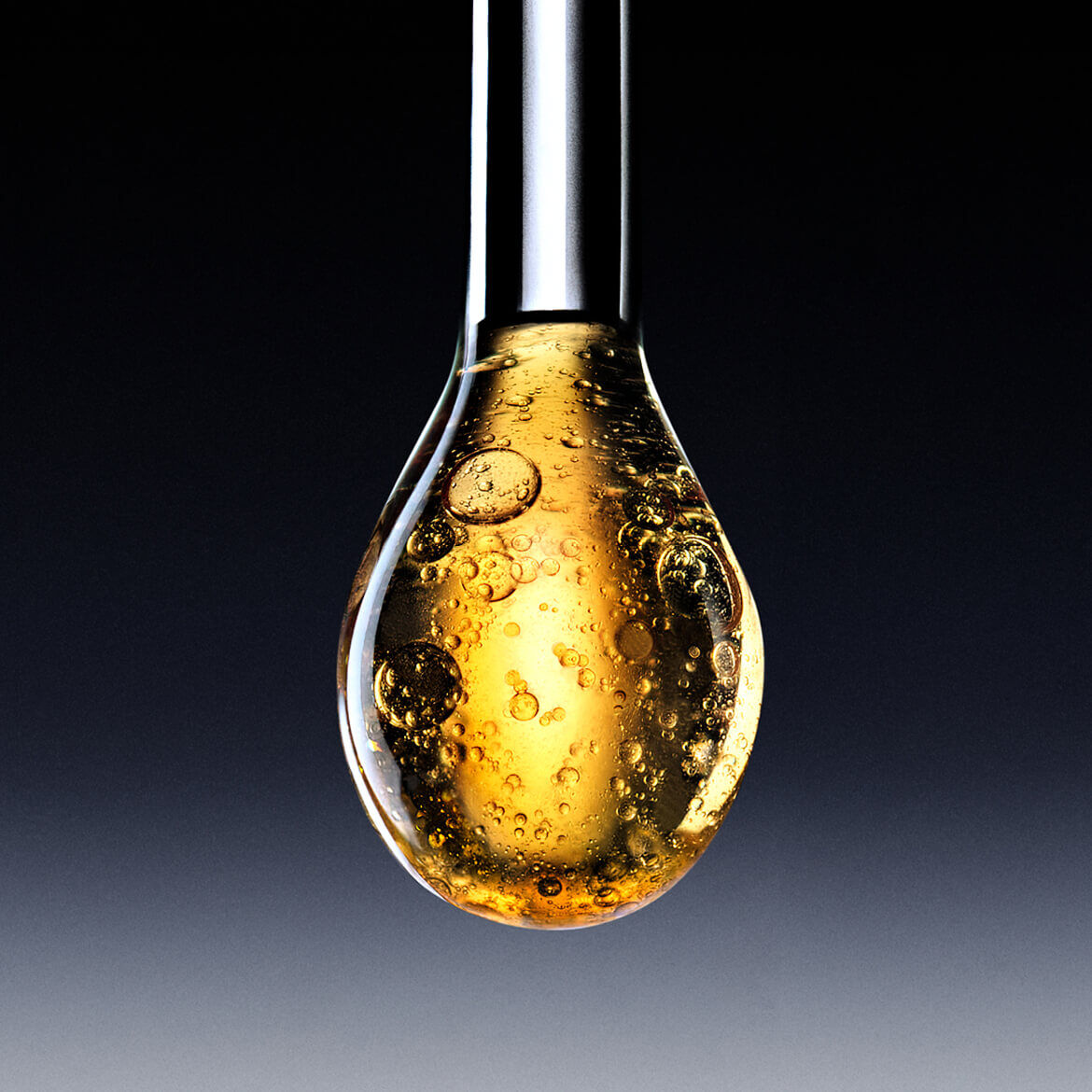 Ein großer Tropfen einer funkelnden goldenen Flussigkeit, wie ein Serum oder Ol, der kurz davor ist, von einem Applikator zu fallen, vor einem dunklen Hintergrund mit Farbverlauf.
